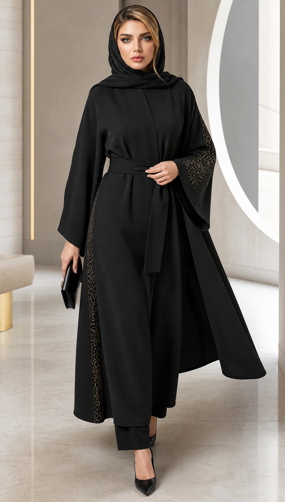 استایل رسمی زنانه با مانتوی عبایی مشکی کمربندی، شلوار مشکی، روسری هماهنگ و جزئیات طلایی ظریف در طراحی آستین و کناره مانتو